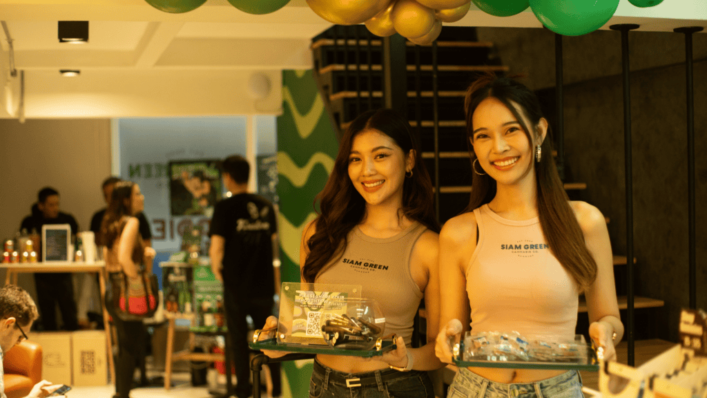 Siam Green 的女性店员手捧产品托盘,笑容自在