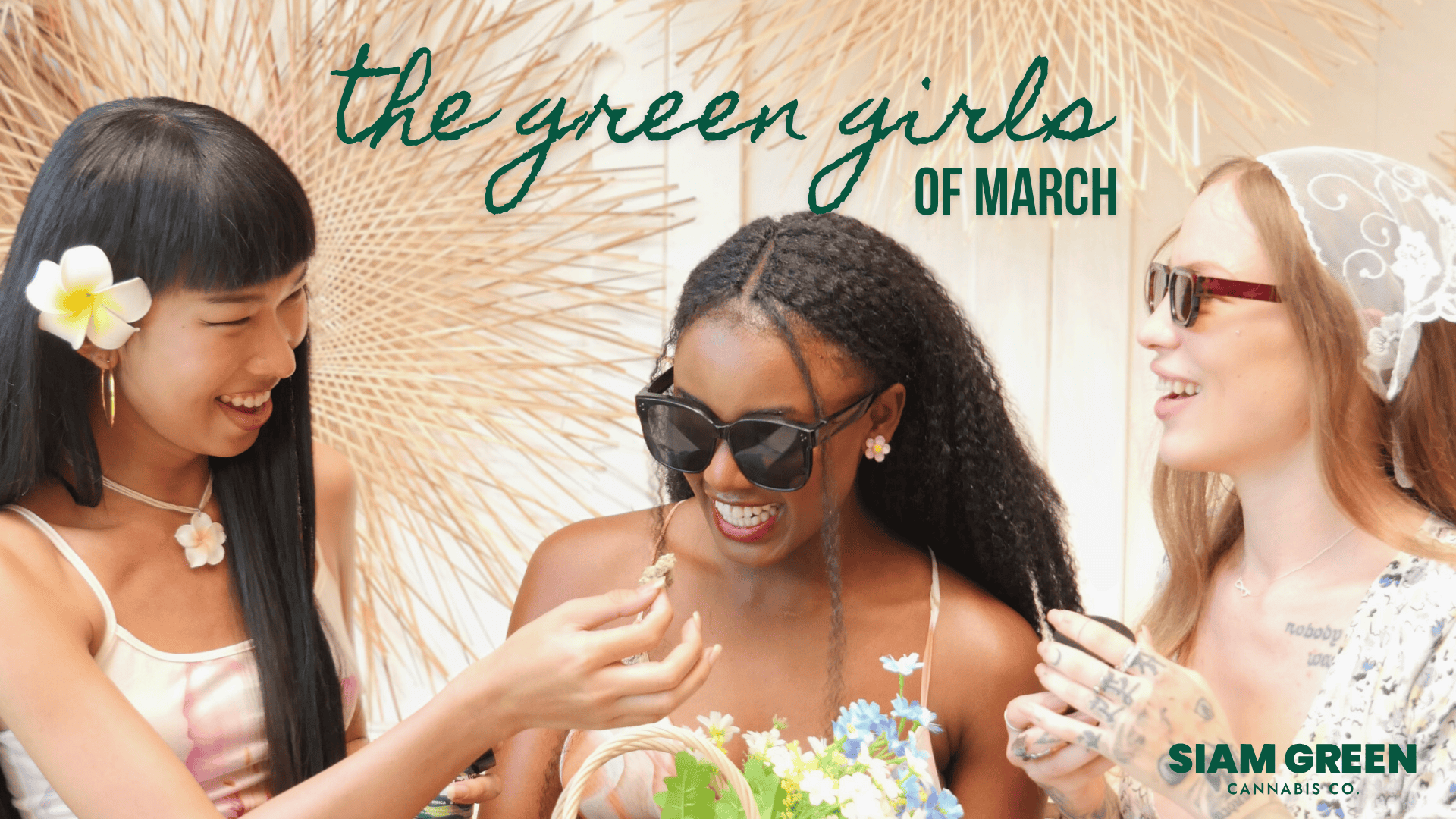 Three women laughing under straw umbrellas with Siam Green logo