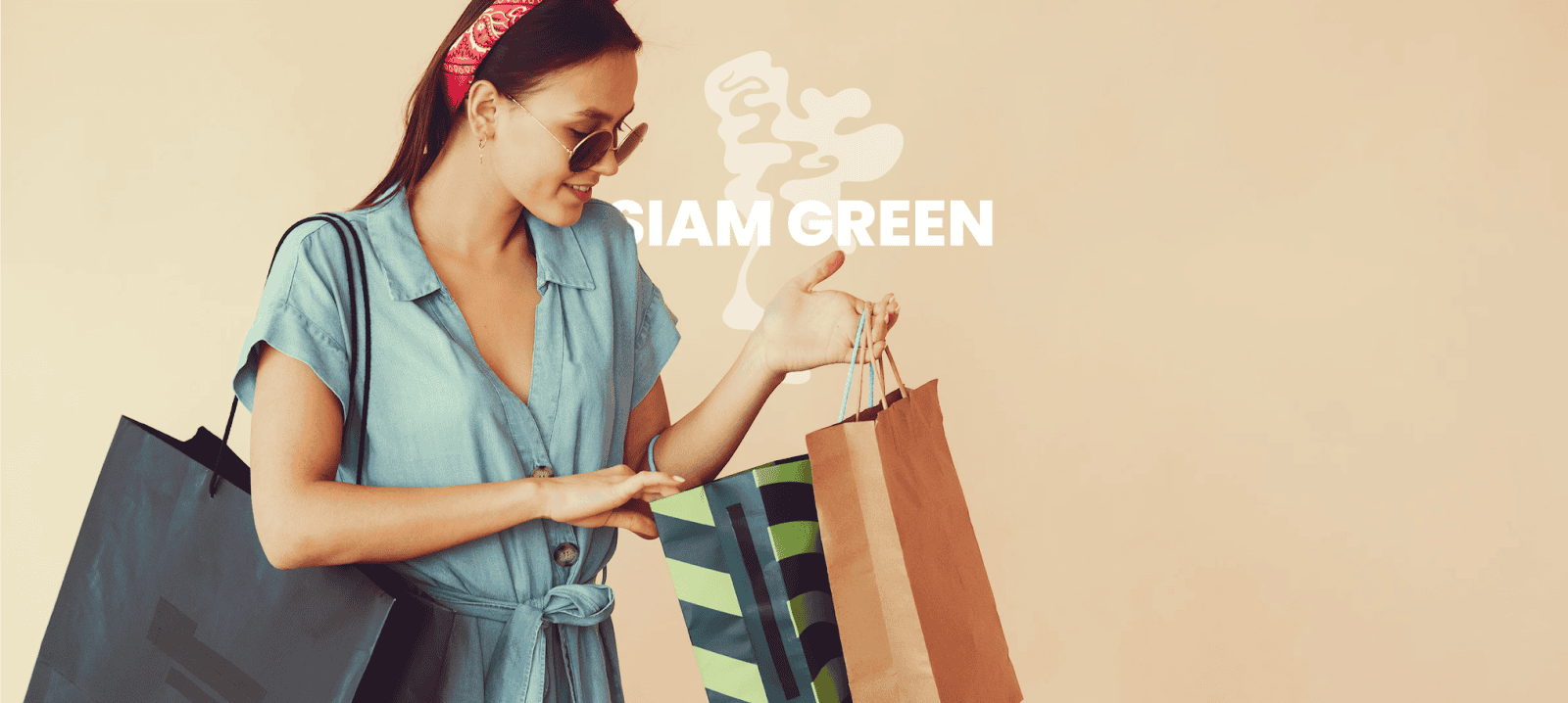 Woman in denim dress carrying Siam Green shopping bags after purchase
